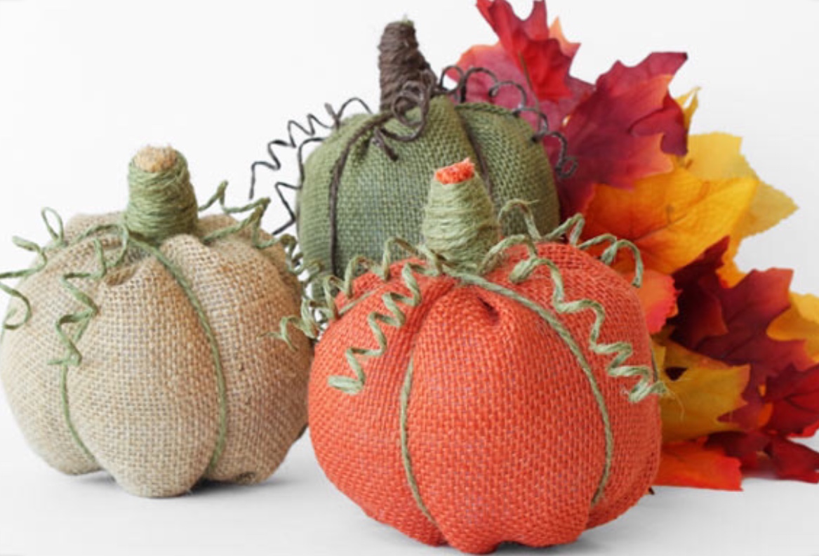 An image of some crafted pumpkin pillows made from burlap.