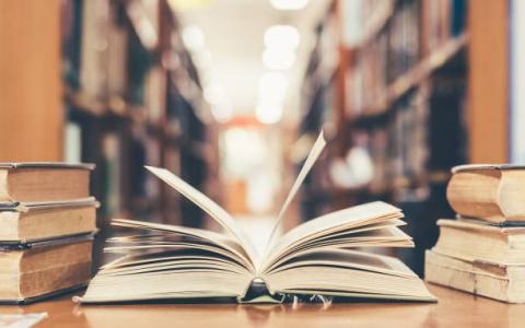 Image of an open book in the library stacks.