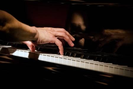 Image of person's hands on piano keys.