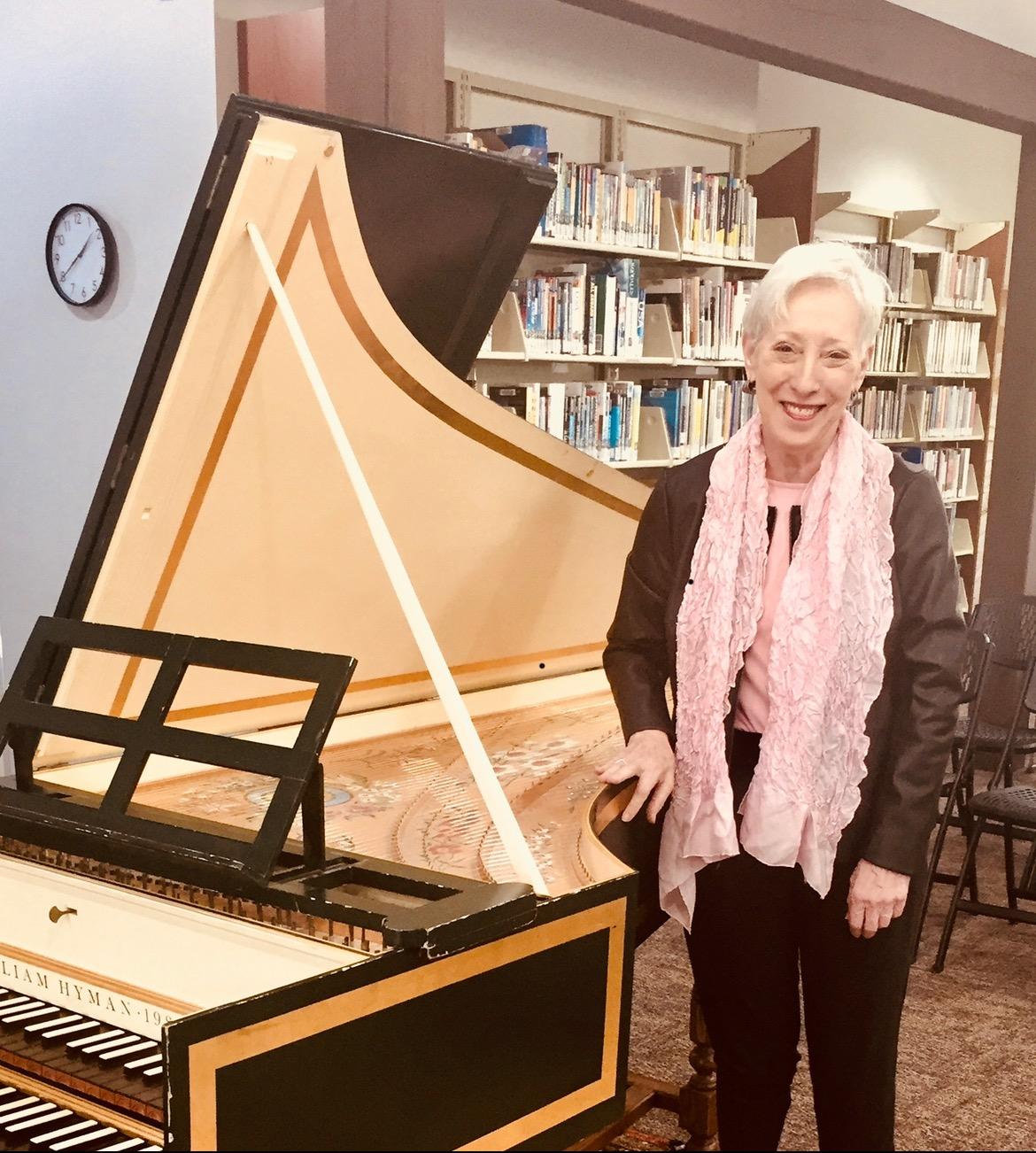 Photograph of Carole Donlin beside the Cutchogue Library Steinway piano.